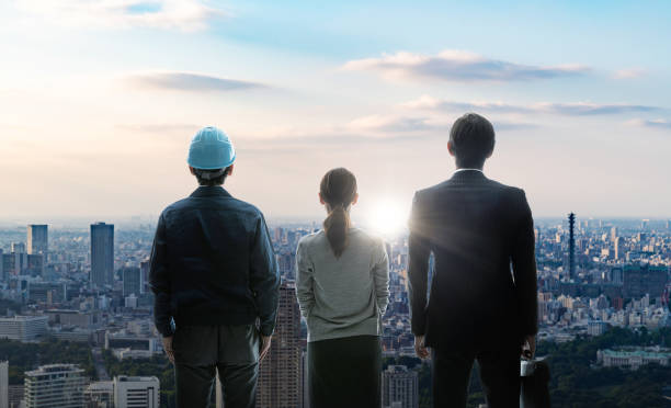 Engineers discussing plans in front of a modern Japanese skyline, symbolizing engineering opportunities in Japan.